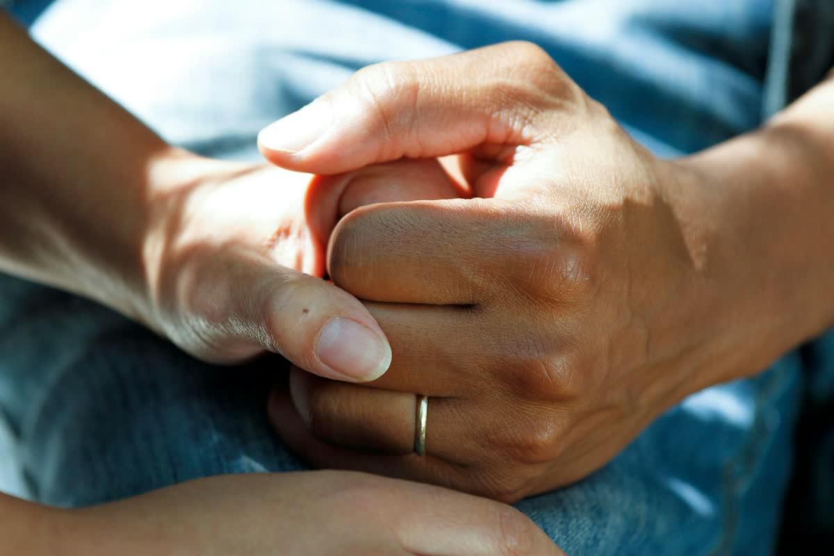 Two hands held together in a gesture of care